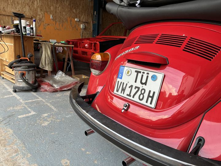 Roter VW Käfer neben der frisch lackierten roten Golf-Karosserie